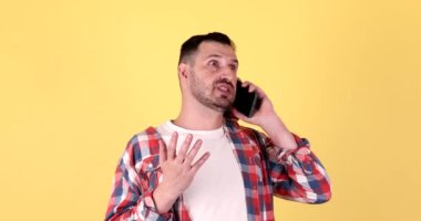 Sarı Arkaplanda Telefonda Konuşan Genç Adam.