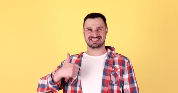 Junger Mann Lächelt Mit Erhobenem Daumen Über Gelbem Hintergrund — Stockvideo