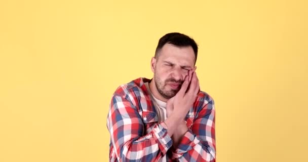 Young Man Touching Cheek Suffering Toothache Yellow Background — Stock Video