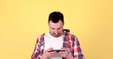 Aman Tanrım, vay canına. Heyecanlı kazanan adam akıllı telefon kullanıyor, sarı arka planda şok oluyor.. 