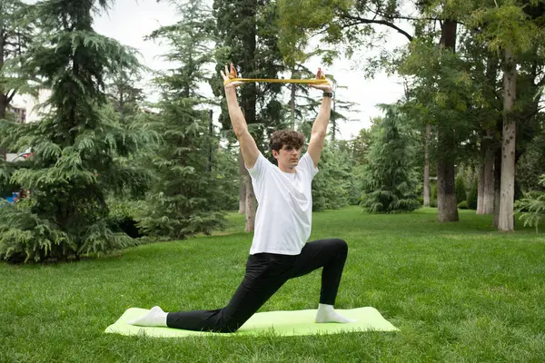 晴れた朝 公園でヨガをする男 ヨガマット健康とアクティブなライフスタイルのコンセプトで屋外で運動する若い男にフィットします アウトドアトレーニング — ストック写真