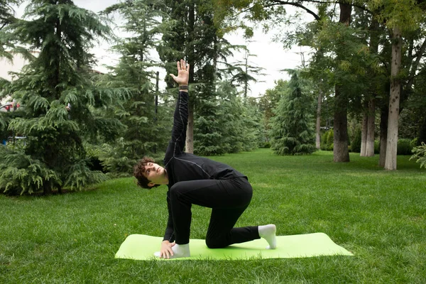 一个人在阳光灿烂的早晨在公园里做瑜伽 适合年轻人在瑜伽垫上进行户外运动健康积极的生活方式理念 室外培训 — 图库照片
