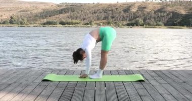 Açık havada yoga eğitimi alan zinde bir bayan. Egzersiz paspasına uzanan zinde bir genç kadın. Fitness, spor, eğitim ve yaşam tarzı konsepti. 