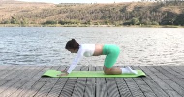 Açık havada yoga eğitimi alan zinde bir bayan. Egzersiz paspasına uzanan zinde bir genç kadın. Fitness, spor, eğitim ve yaşam tarzı konsepti. 