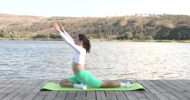 Açık havada yoga eğitimi alan zinde bir bayan. Egzersiz paspasına uzanan zinde bir genç kadın. Fitness, spor, eğitim ve yaşam tarzı konsepti. 