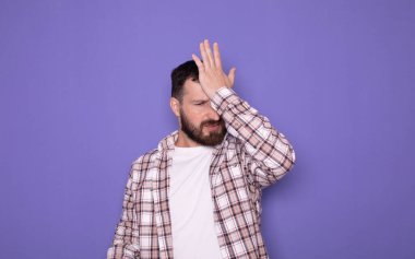 Genç yakışıklı adam üzgün, hayal kırıklığına uğramış, mor arka planda kızgın.