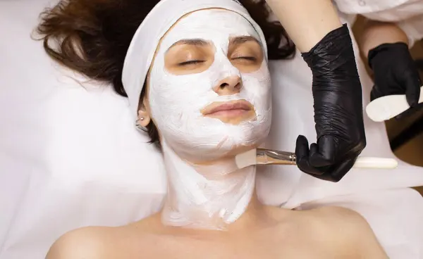Jeune Belle Femme Recevant Masque Facial Blanc Dans Salon Beauté — Photo