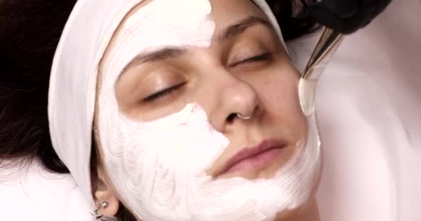Молода Красива Жінка Отримує Білу Маску Обличчя Салоні Краси — стокове відео