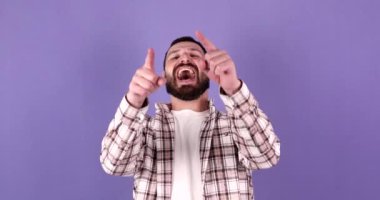 Yakışıklı, beyaz sakallı genç adam kamerayı bir kenara bırak büyüleyici gülümseme mor arka plan stüdyo resminde izole edilmiş. Halk yaşam tarzı konsepti