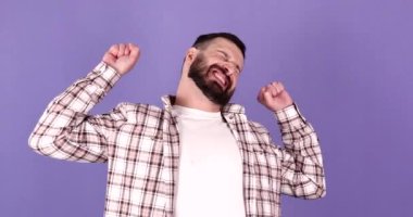 Genç sakallı adam mor arka planda uyanıyor..