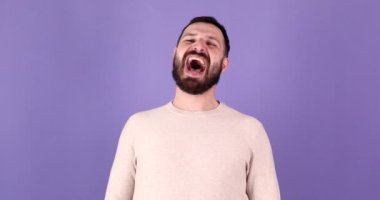 Mor arka plan stüdyo resmine izole edilmiş yakışıklı beyaz sakallı adam poz veriyor ve gülüyor. Halk yaşam tarzı konsepti