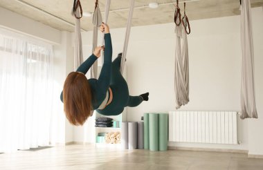 Genç kız yoga ve esneme hareketleri, yoga eğitimi, sinek yogası, aero esneme, hava yogası hamağı, pilates terapisi konsepti.. 