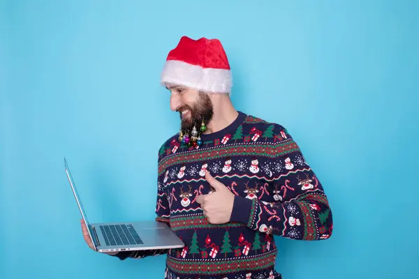 Bärtiger Mann Mit Strickpullover Und Weihnachtsmütze Posiert Mit Laptop Auf — Stockfoto