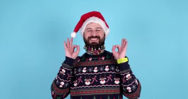 Huzurlu bir adam stüdyoda meditasyon yapıyor. Santa Hat 'ta sakallı bir adamın portresi dinleniyor ve parmaklarıyla meditasyon yapıyor..