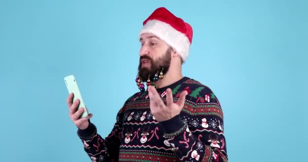 Szczęśliwy Brodaty Człowiek Pomocą Smartfona Mężczyzna Kapeluszu Mikołaja Uśmiecha Się — Wideo stockowe
