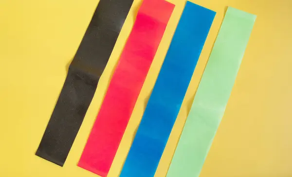 Set Bandas Elásticas Multicolores Brillantes Para Fitness Sobre Fondo Amarillo —  Fotos de Stock