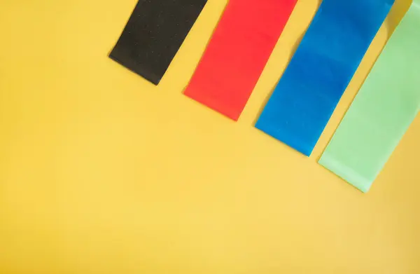 Набор Ярких Разноцветных Резиновых Лент Фитнеса Желтом Фоне Спортивная Концепция — стоковое фото