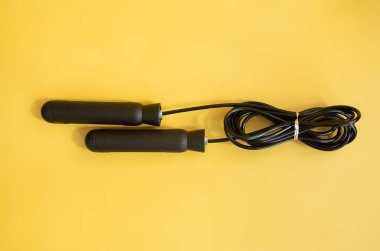 Sarı arka planda siyah saplı ip atlama.