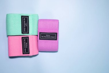 Mavi arka planda fitness için renkli kalça direnci bantları. spor konsepti.      