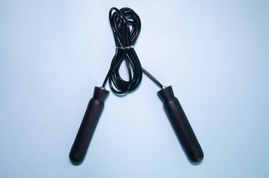 Mavi arkaplanda siyah saplı ip atlanıyor.