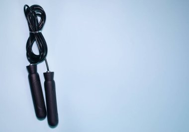 Mavi arkaplanda siyah saplı ip atlanıyor.