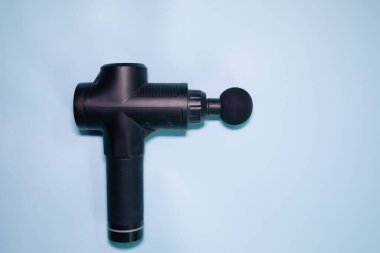 Machine for body massage on blue background. Massage gun.  