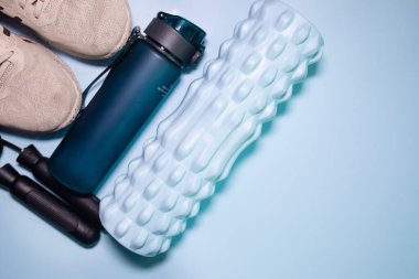 Mavi arka planda antrenman yapmak için gerekli aletlerin en üst görüntüsü. Fitness, spor malzemeleri, sağlıklı yaşam tarzı konsepti.      