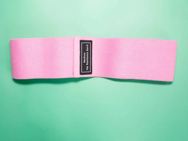 粉色髋关节阻力带 适合绿色背景的健身 体育概念 — 图库照片