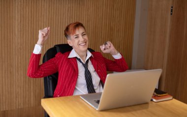 Kırmızı elbiseli orta yaşlı kadın gülümsüyor ofiste rahatlıyor..