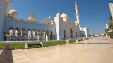 Tepesinde büyük bir kubbe olan güzel beyaz bir bina. Bina yemyeşil bir avluyla çevrili.