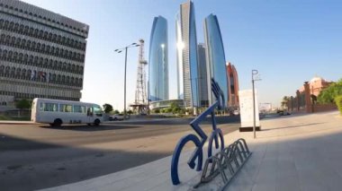 Dubai, BAE, 30 Mart 2024. Mavi bir bisiklet büyük bir binanın önündeki kaldırımda bir bisiklet parkının yanında duruyor.