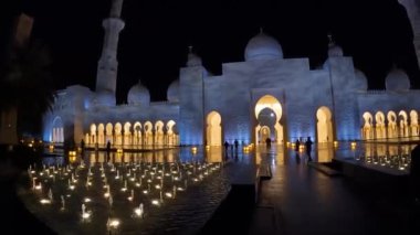 Dubai, BAE, 30 Mart 2024. Tepesinde büyük bir kubbe olan büyük bir bina. Bina gece aydınlanıyor ve insanlar binanın etrafında dolanıyor.