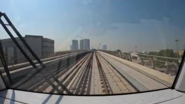 Dubai, BAE, 30 Mart 2024. Üzerinden tren geçen bir şehir silueti. Tren, binalarla çevrili bir raydaydı.