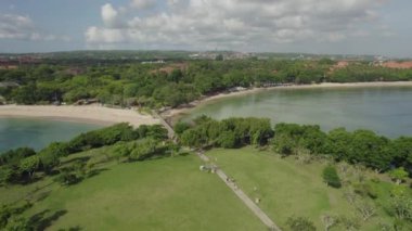 Arka planda tatil köyü olan güzel bir sahil manzarası.            