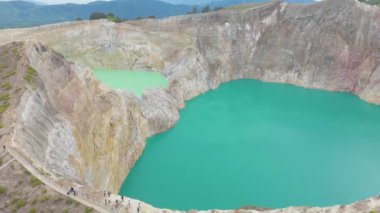 Endonezya 'da. Flores 'teki Kelimutu volkan krateri. İki büyük su kütlesi, yeşil ve mavi. Manzara sakin ve huzurlu, su çevreyi yansıtıyor..             
