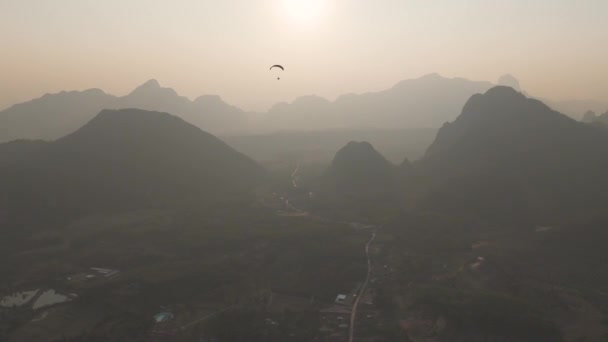 ヴァンヴィエン ラオス 11月2023日 下の都市と美しい自然の上にパラグライダーを飛んでいる人々 — ストック動画