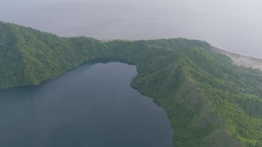 Sumbawa, Endonezya. Yeşil ormanı ve mavi okyanusu olan büyük bir ada. Ada suyla çevrili ve ortasında büyük bir krater var.
