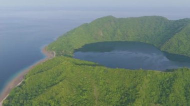 Sumbawa, Endonezya. Yeşil ormanı ve mavi okyanusu olan büyük bir ada. Ada suyla çevrili ve ortasında büyük bir krater var.