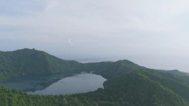 Sumbawa, Endonezya. Yeşil ormanı ve mavi okyanusu olan büyük bir ada. Ada suyla çevrili ve ortasında büyük bir krater var.
