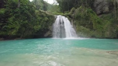 Kawasan şelaleleri, Cebu, Filipinler. Bir şelale mavi bir havuza akıyor. Su berrak ve sakin. Huzurlu ve huzurlu bir sahne..