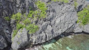 Kayalık kıyıları ve dağları olan güzel bir okyanus manzarası. Su sakin ve berrak..      