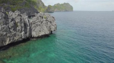 Kayalık kıyıları ve dağları olan güzel bir okyanus manzarası. Su sakin ve berrak..      
