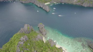 Kayalık kıyı şeridi ve yüzen tekneleri olan güzel mavi okyanuslar. Palawan, Filipinler 'de İnanılmaz Büyük Göl
