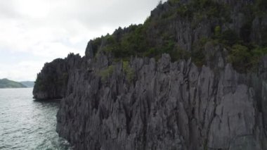 Kayalık kıyı şeridi ve yüzen tekneleri olan güzel mavi okyanuslar. Palawan, Filipinler 'de İnanılmaz Büyük Göl