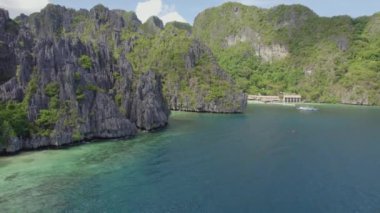 El Nido, Palawan, Filipinler 'deki muhteşem Büyük Göl manzarası. Kayalık bir kıyıya yakın okyanusta yüzen tekneler.   