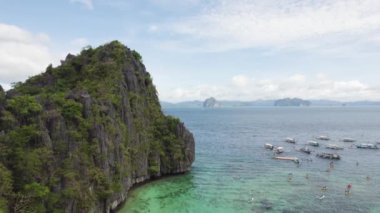 El Nido, Palawan, Filipinler 'deki muhteşem Büyük Göl manzarası. Kayalık bir kıyıya yakın okyanusta yüzen tekneler.   