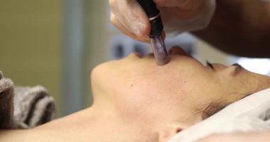 Güzellik salonunda yüz bakımı gören genç bir kadın.                    