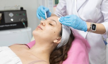 Modern güzellik salonundaki genç bayana gençleştirici prosedür uygulayan profesyonel kadın güzellik uzmanı..              