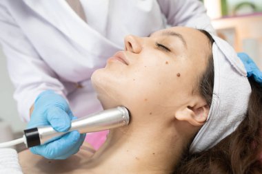 Radyo frekansı yüzünde kaldırma almak güzel bir kadın. Profesyonel Şevval Özçelik Güzellik yüz anti-kırışıklık tedavisi yapıyor. Cilt Bakımı ve cilt dokusunu düzeltilmesi kavramı.