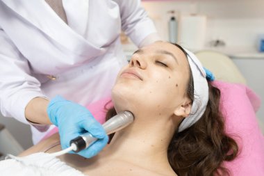 Radyo frekansı yüzünde kaldırma almak güzel bir kadın. Profesyonel Şevval Özçelik Güzellik yüz anti-kırışıklık tedavisi yapıyor. Cilt Bakımı ve cilt dokusunu düzeltilmesi kavramı.